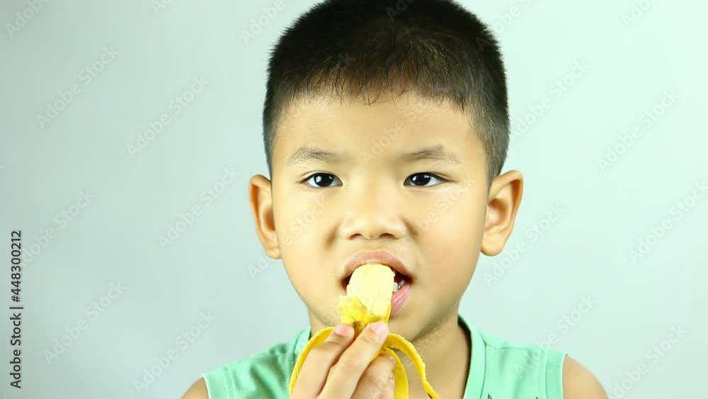 Thai child eating banana, in studio Chiangmai Thailand. Thai child eating banana, in studio Chiangmai Thailand.