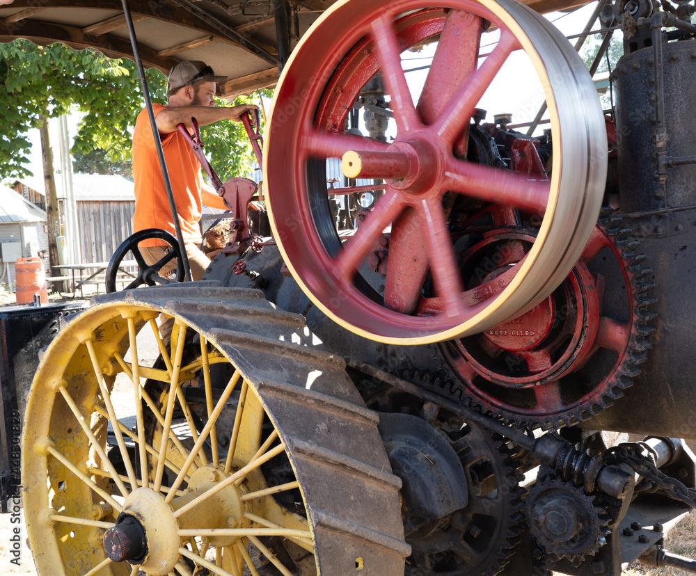 Salem, Oregon - 7-27-2021: The iron spoked rear wheels and fly wheel of a vintage steam powered farm tractor, operating at Powerland Heritage Park at  the steam-up, in Salem Oregon