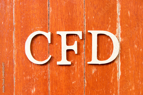 Alphabet letter in word CFD (Abbreviation of Contract for Difference) on old red color wood plate background