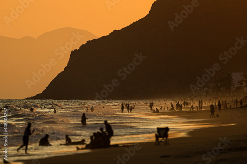 Bathers or vacationers on the beach at sunset ,beach, sea, sunset, sand, ocean, water, people, couple, walking, waves, nature, coast, summer, sky, sun, surf, silhouette, wave, vacation,  photo