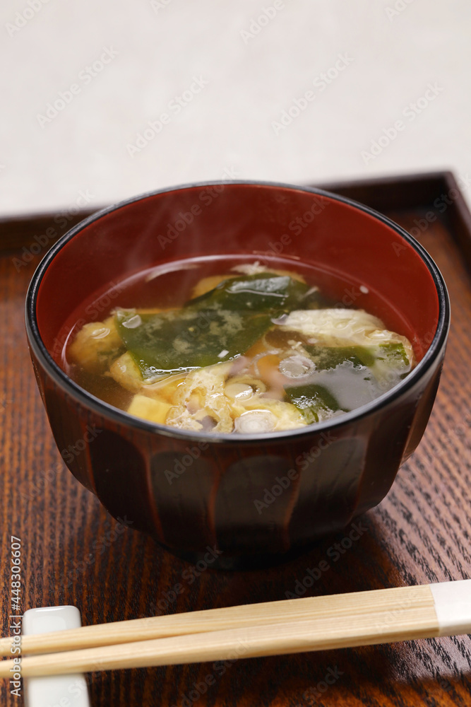 Japanese miso soup, additional ingredients such as green onion, wakame seaweed, and fried tofu.