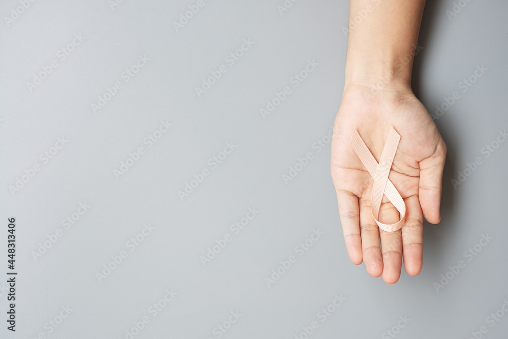 September Uterine Cancer Awareness month, woman hand holding Peach Ribbon for supporting people living and illness. Healthcare and World cancer day concept September Uterine Cancer Awareness month, woman hand holding Peach Ribbon for supporting people living and illness. Healthcare and World cancer day concept