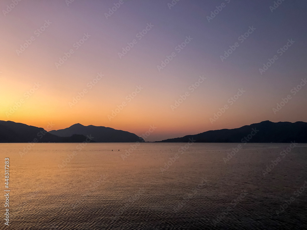 Tourist admiring the sunrise on tropical island - stock photo