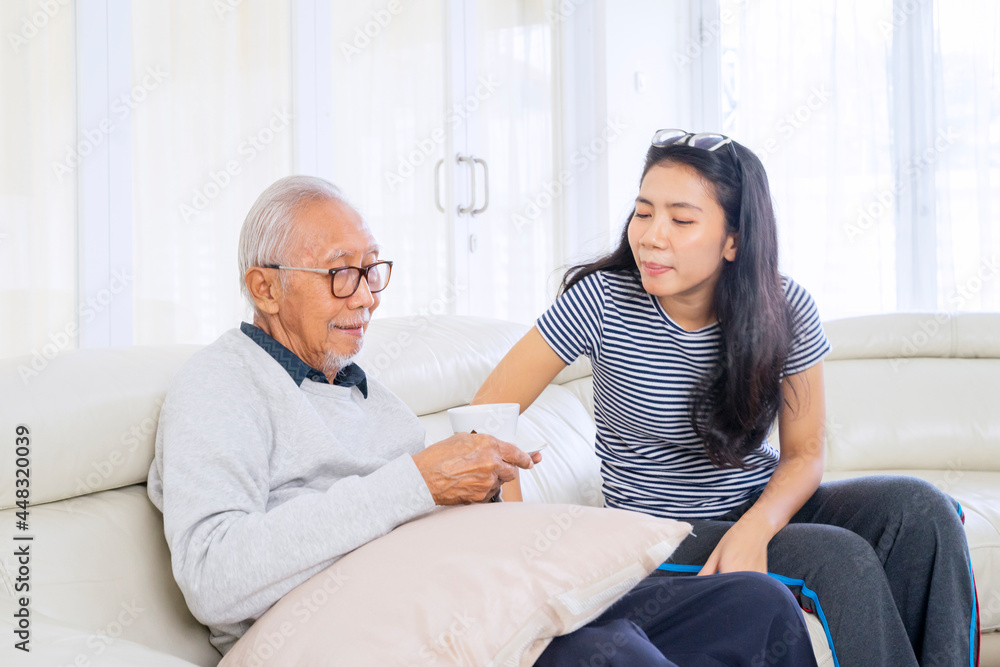 Obraz premium Old man holding a cup while talking with daughter