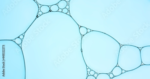 Oil droplets create shapes and pattern on blue backgrounds. 