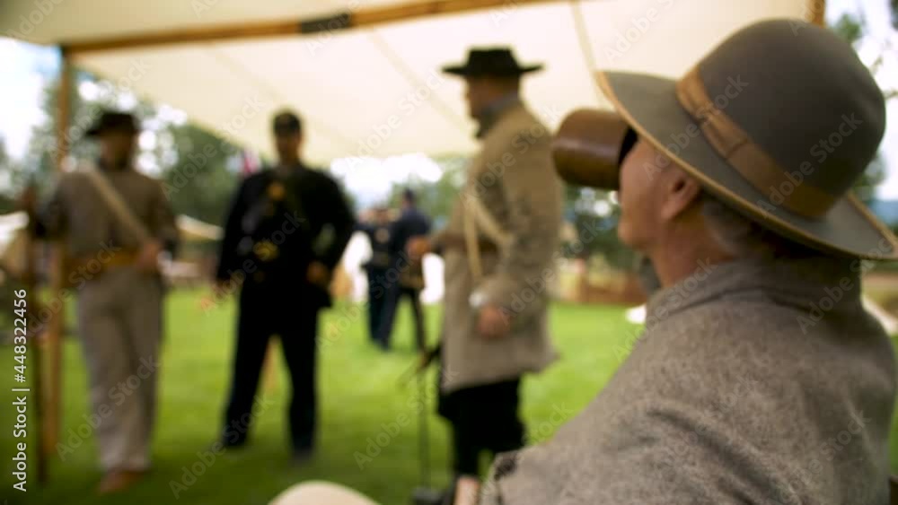 Civil War Soldiers standing in a tent talking and having a drink from a cup Civil War Soldiers standing in a tent talking and having a drink from a cup