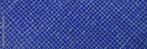 Blue mosaic tiles at bottom of transparent pool