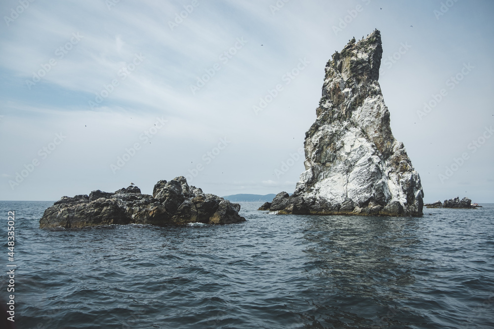 wild white rocks in a clear deep blue sea. selective focus