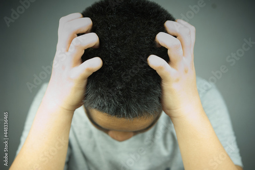 Close up of boy scratching the head.