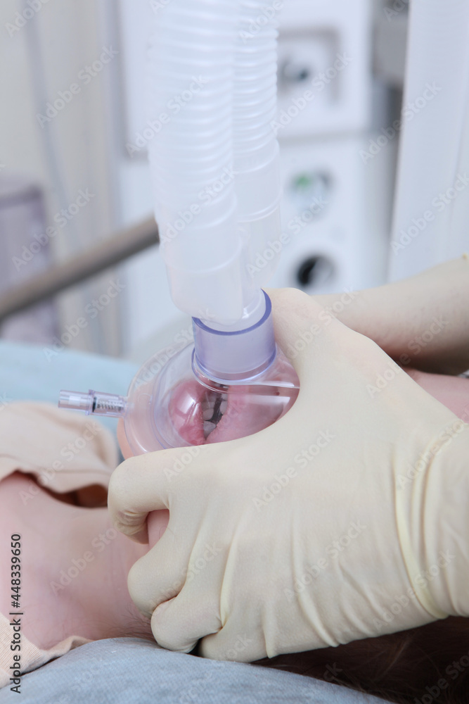 Before the operation, the child was put on an oxygen mask. Anesthesia for the child. Anesthesiologist and resuscitator.Health care and life saving concept. Vertical photo.Life saving. Before the operation, the child was put on an oxygen mask. Anesthesia for the child. Anesthesiologist and resuscitator.Health care and life saving concept. Vertical photo.Life saving.