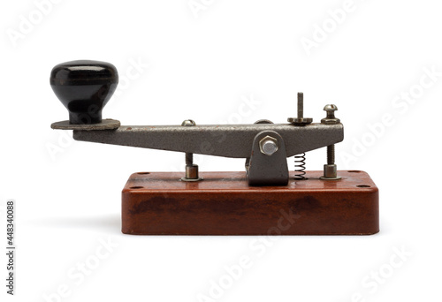Telegraph key or Morse key isolated on white background. Vintage Morse code telegraphy device side view. photo