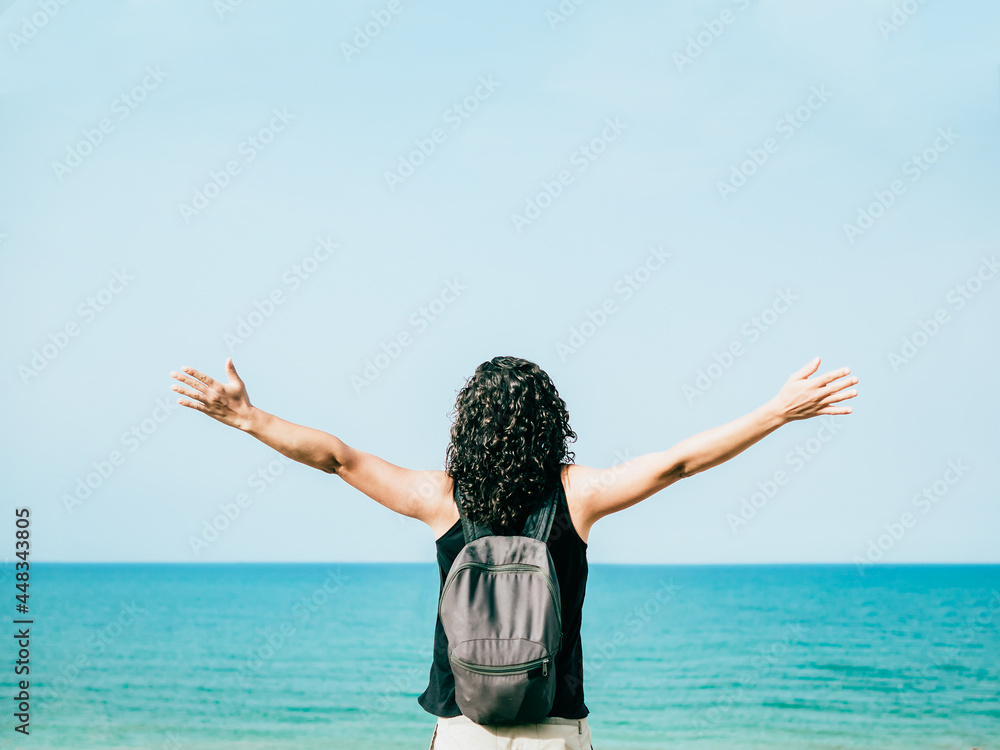 Woman with open arms in front of the sea showing a sense of freedom. Woman with open arms in front of the sea showing a sense of freedom.