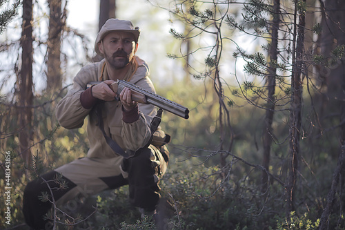 man goes hunting forest summer / landscape in the forest, huntsman with a hunting rifle hunts