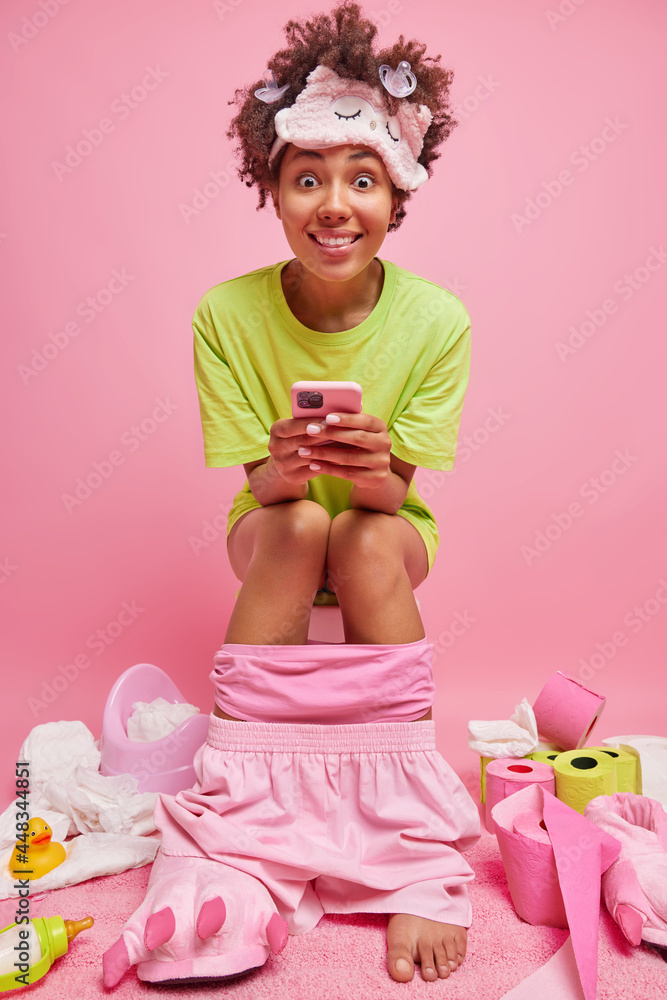 Good looking positive Afro American woman uses mobile phone while ...