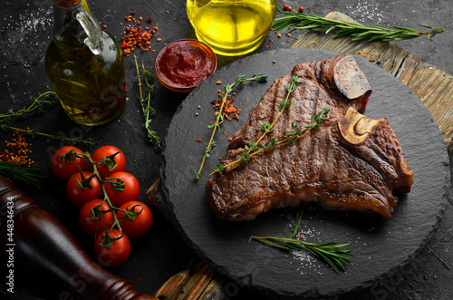 Aged Beef T-Bone steak. Juicy cooked steak with rosemary and spices. Top view. Rustic style. Flat Lay.