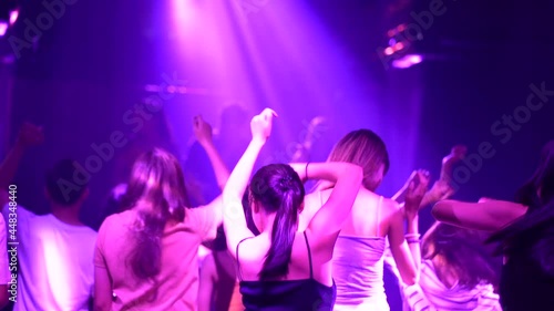 Women and men have fun in dance party. Group of young people dancing in night club. photo