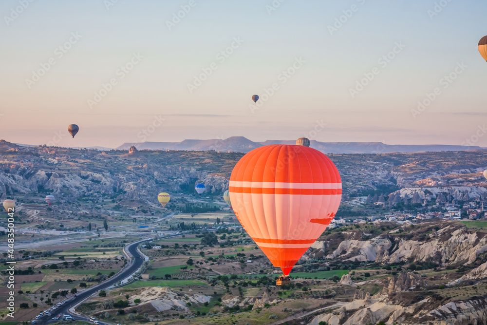 Hot air balloons flying over the valley at Cappadocia, Turkey. Goreme Balloon Festival. Beautiful hot air balloons take off at sunrise. Hot air balloons in the blue sky