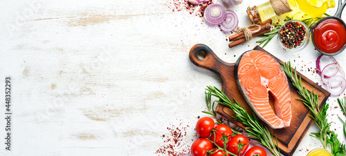 Salmon steak and ingredients on white wooden background. Top view. Free space for your text.