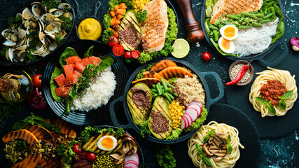 Set of food in plates: pasta, chicken, meat, mushrooms. Dietary food. A bowl of Buddha. Top view. Free space for text.