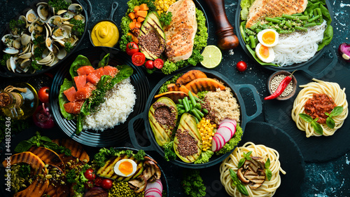 Set of food in plates: pasta, chicken, meat, mushrooms. Dietary food. A bowl of Buddha. Top view. Free space for text.