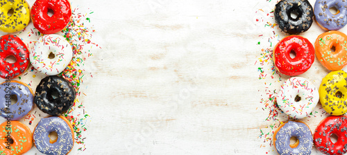 Set of sweet colored donuts on a white wooden background. Top view. Flat Lay.