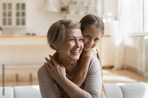 Bild auf Leinwand Head shot smiling mature grandmother piggy backing cute little granddaughter, si