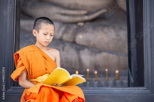 Young novice monk reading a book in Wat Phutthai Sawan Temple, Ayutthaya