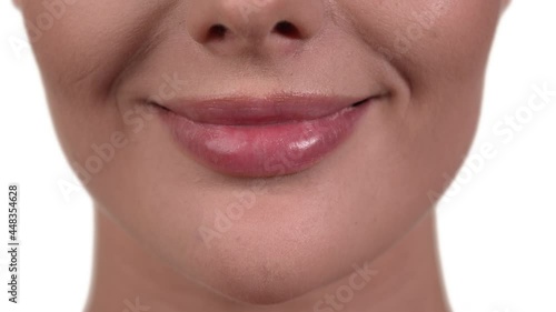 Close up of a Caucasian woman's mouth, sucking her bottom lip and pouting. White background. photo