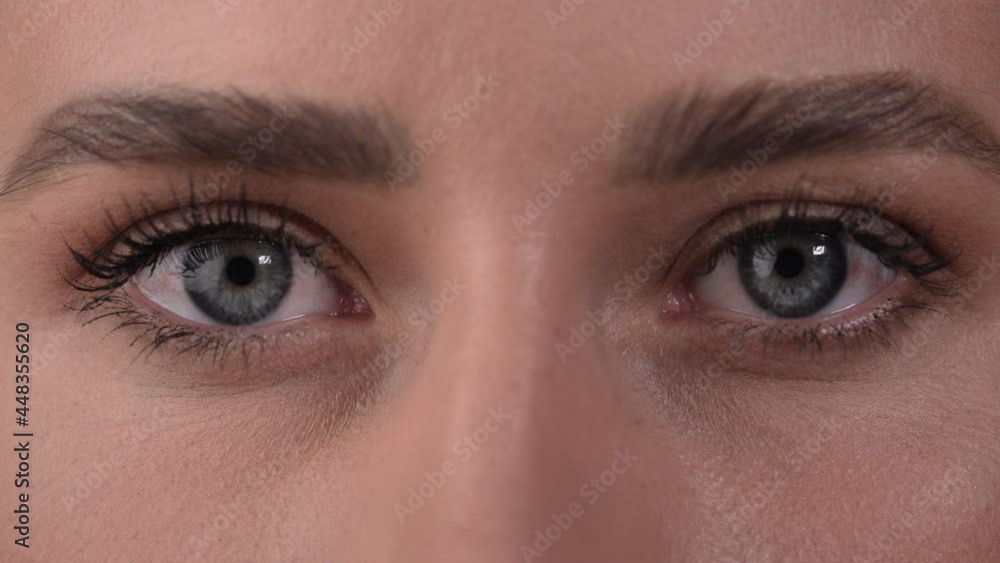 Close up of a Caucasian woman's eyes, closing for a while and opening her eyes. White background. Close up of a Caucasian woman's eyes, closing for a while and opening her eyes. White background.