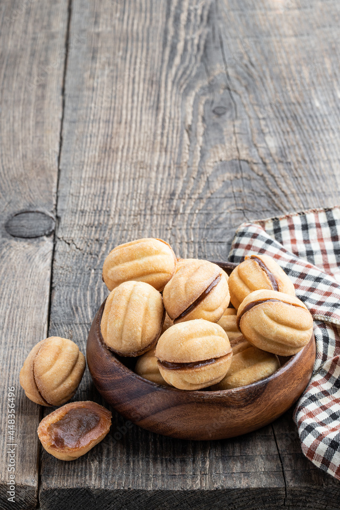 traditional russian walnut tea-cakes in wooden bowl on rustic table traditional russian walnut tea-cakes in wooden bowl on rustic table