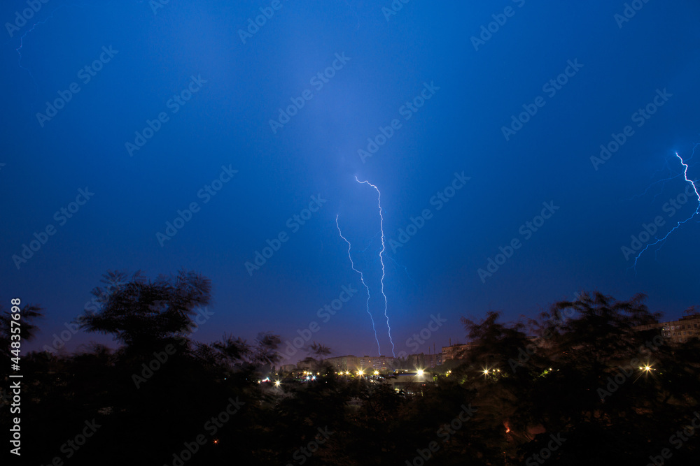 Lightning discharges during a large rainstorm in a city with forest fringes Lightning discharges during a large rainstorm in a city with forest fringes