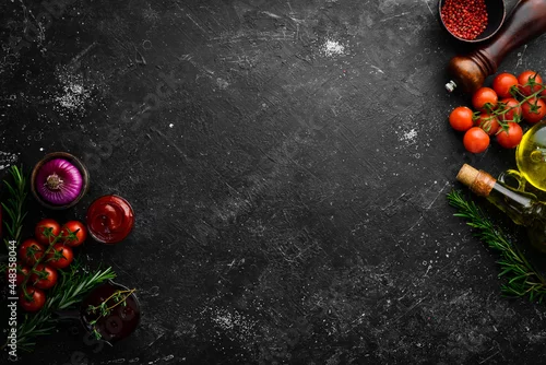 Obraz  z motywem Black stone cooking background. Spices and vegetables. Top view. Free space for your text.