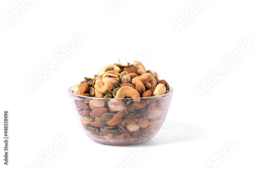 many snack nuts pumpkin seeds, pistachios, macadamia nuts, cashew nut, almond in glass bowl on white background. Vegetarian or vegan snake. Healthy food eating.