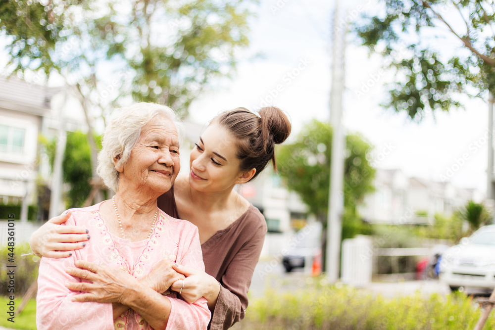 Happy elderly woman with a caregiver in the garden, Home care concept...