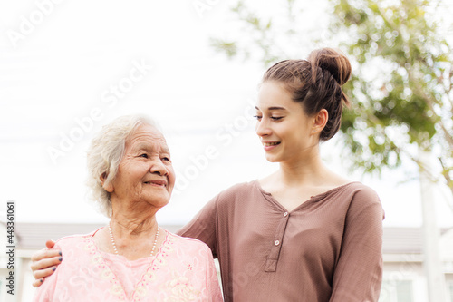 Happy elderly woman with a caregiver in the garden, Home care concept...