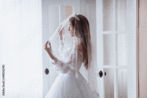 Beautiful bride with light make-up in white dress in an exquisite interior 