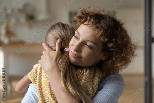 Close up caring young mother hugging adorable little daughter, loving mom and preschool girl kid child family enjoying tender moment, new mom for adopted child, warm good relationships concept