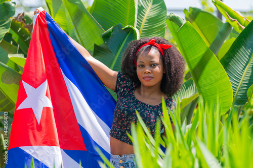 Photography Afro woman with a Cuban flag outdoors
