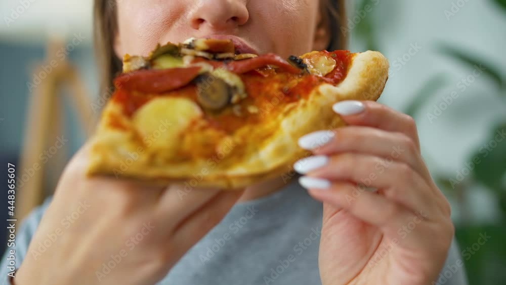 Woman eating pizza. Close-up. Concept of quick bites and unhealthy food Woman eating pizza. Close-up. Concept of quick bites and unhealthy food