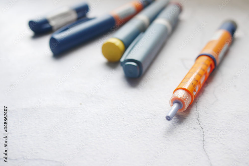 Insulin pens on wooden background, close up Insulin pens on wooden background, close up