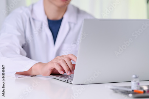 doctor checked the patient s history and used a laptop to record patient information at doctor room the hospital medical concept