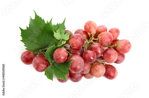 Cluster of ripe red grapes with green leaves on white background, top view