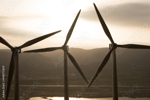 concept idea eco power energy. wind turbine on hill with sunset. Wind Turbine producing alternative energy.