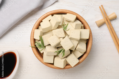 Delicious tofu with rosemary served on white wooden table, flat lay