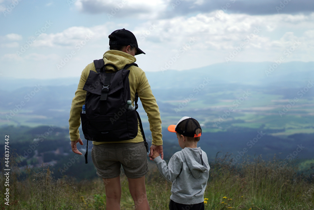 Young female tourist standing with her son and enjoying beautiful view in the mountains, Slovakia, High Tatras
