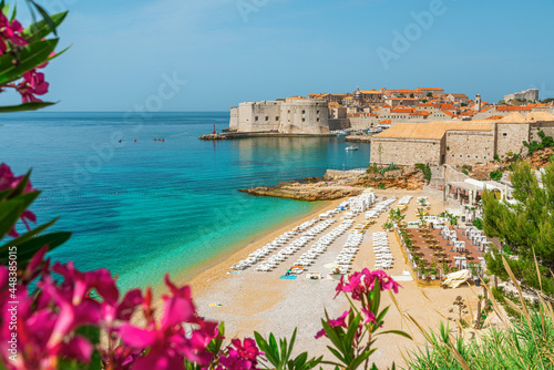 Fototapeta Naklejka Na Ścianę i Meble -  Beautiful view of Banje beach and old town of Dubrovnik with summer flowers in Croatia