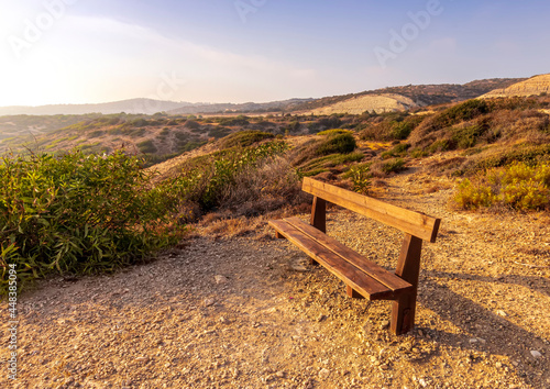 amazing scenic view at a sea shore from a mountain with nice bench on the foreground and blue sky and sea on the background , rest on a rock landscape