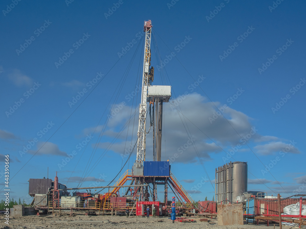 The drilling rig is included in the landscape of the oil and gas field. Infrastructure, communications and drilling equipment are visible. The drilling rig has equipment for well cementing The drilling rig is included in the landscape of the oil and gas field. Infrastructure, communications and drilling equipment are visible. The drilling rig has equipment for well cementing