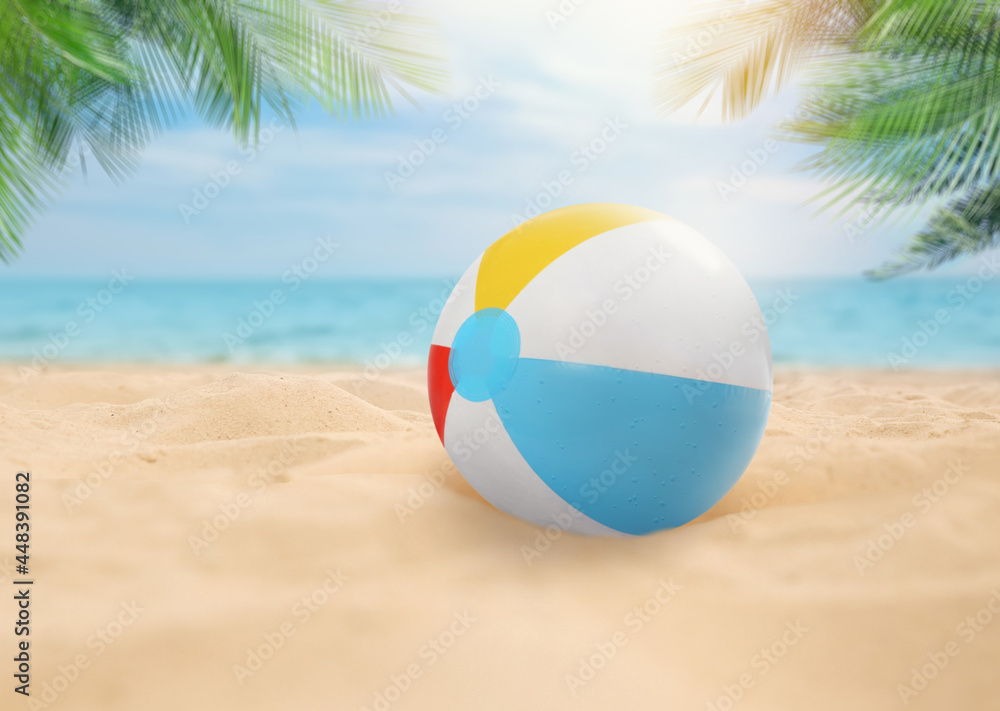 Obraz premium Colorful beach ball on sandy coast near sea