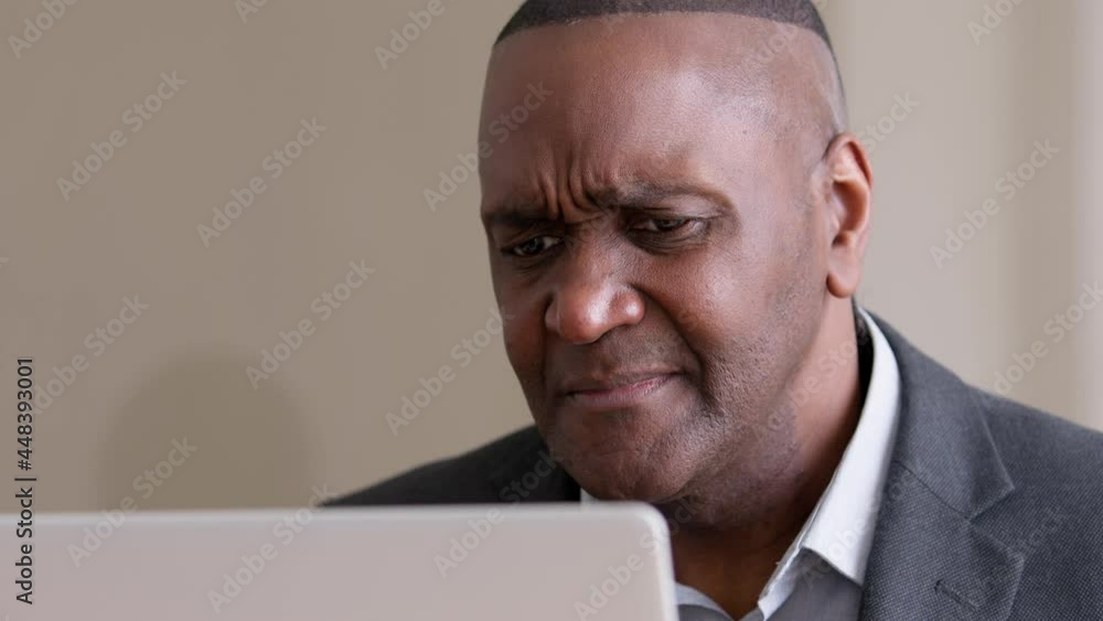 Close-up male wrinkled emotional face mature adult elderly african american business man leader boss user looking at laptop screen feeling frustrated disgusted receives bad notice news in computer Close-up male wrinkled emotional face mature adult elderly african american business man leader boss user looking at laptop screen feeling frustrated disgusted receives bad notice news in computer